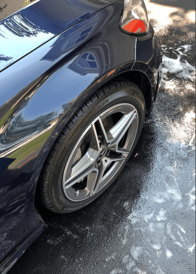 Close-up of a dark glossy panel and wheel after a paint coating
