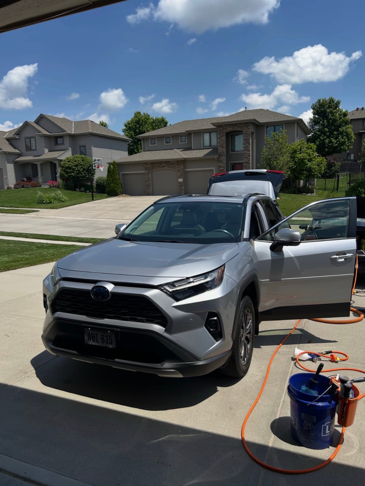 Silver SUV being detailed in a Kansas City suburban driveway